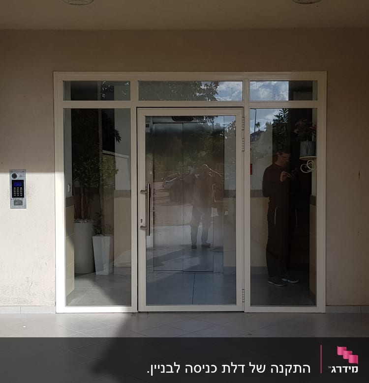 דלת זכוכית עם מסגרת אלומיניום בכניסה לבניין